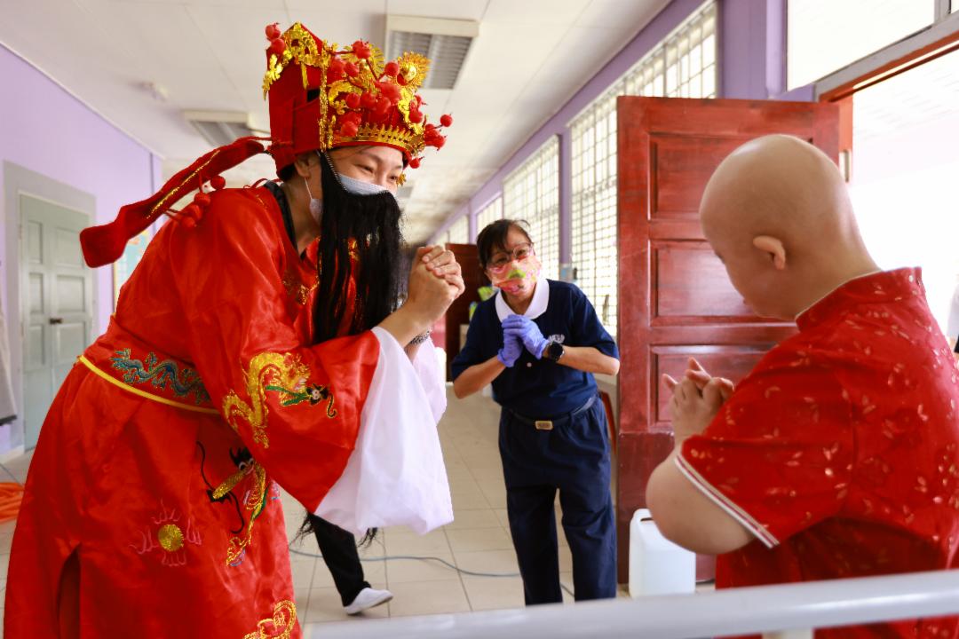 Love and smiles transcend all barriers. This Lunar New Year, volunteers spread warmth and joy to the residents of Taman Sinar Harapan. [Photo by Leong Chian Yee]
