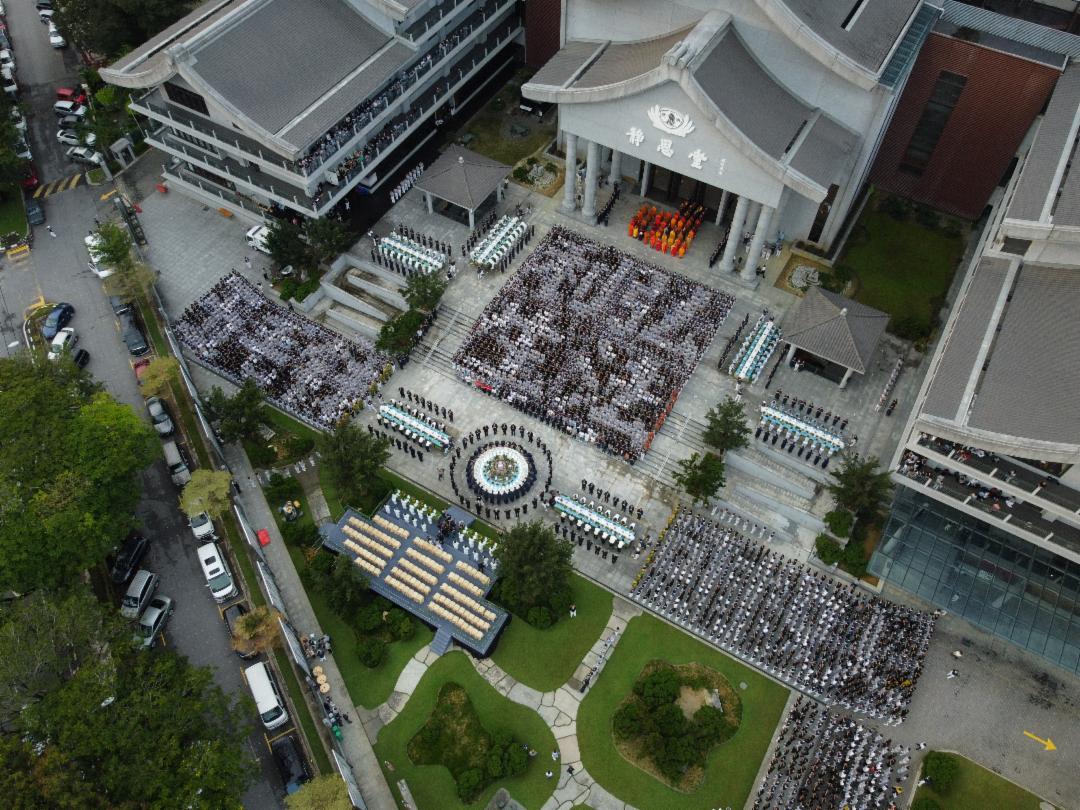 The formation of the Chinese characters “弘法利生” (spreading the Dharma and benefiting all beings) and “五毛钱可救人” (50 cents can save lives) exemplified the steadfast mission of Tzu Chi volunteers. [Photo by Boon Wui Kong]